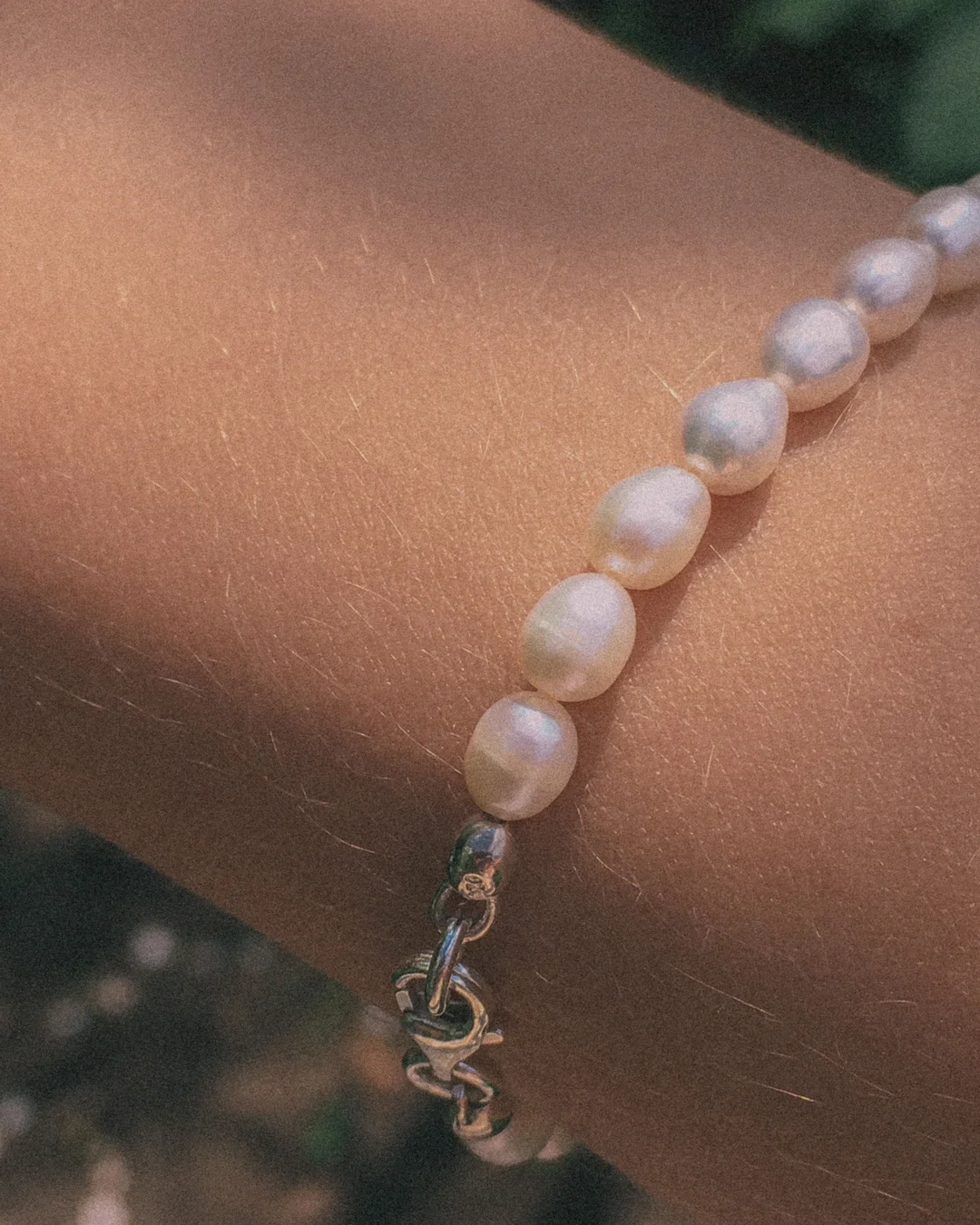 Poignet portant un bracelet de perles baroques — visuel temporaire de construction (Pexels, Maria Naichenko)